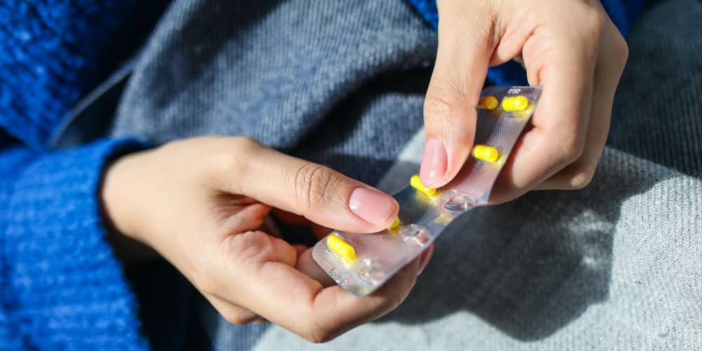 a person holding a medicine and taking it for medication
