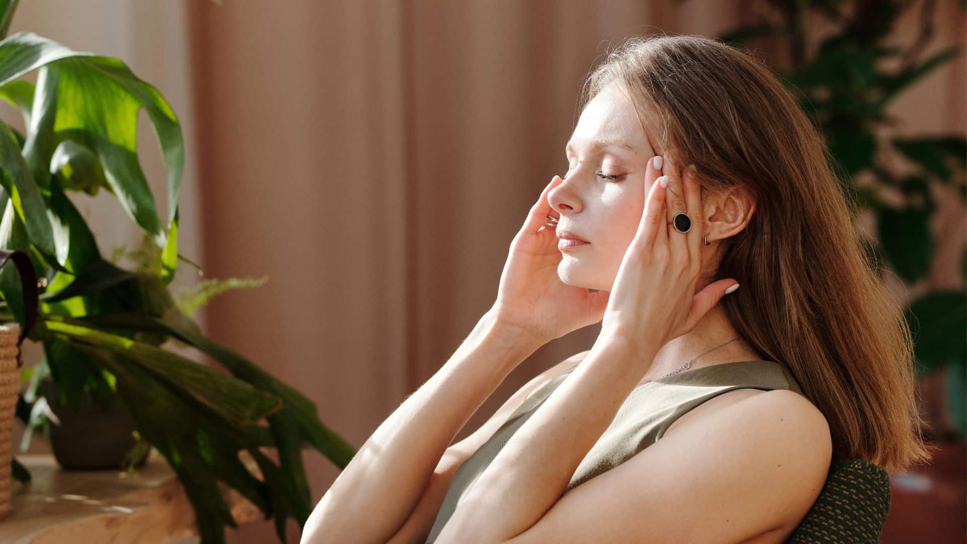 picture of woman sitting and experiencing headache
