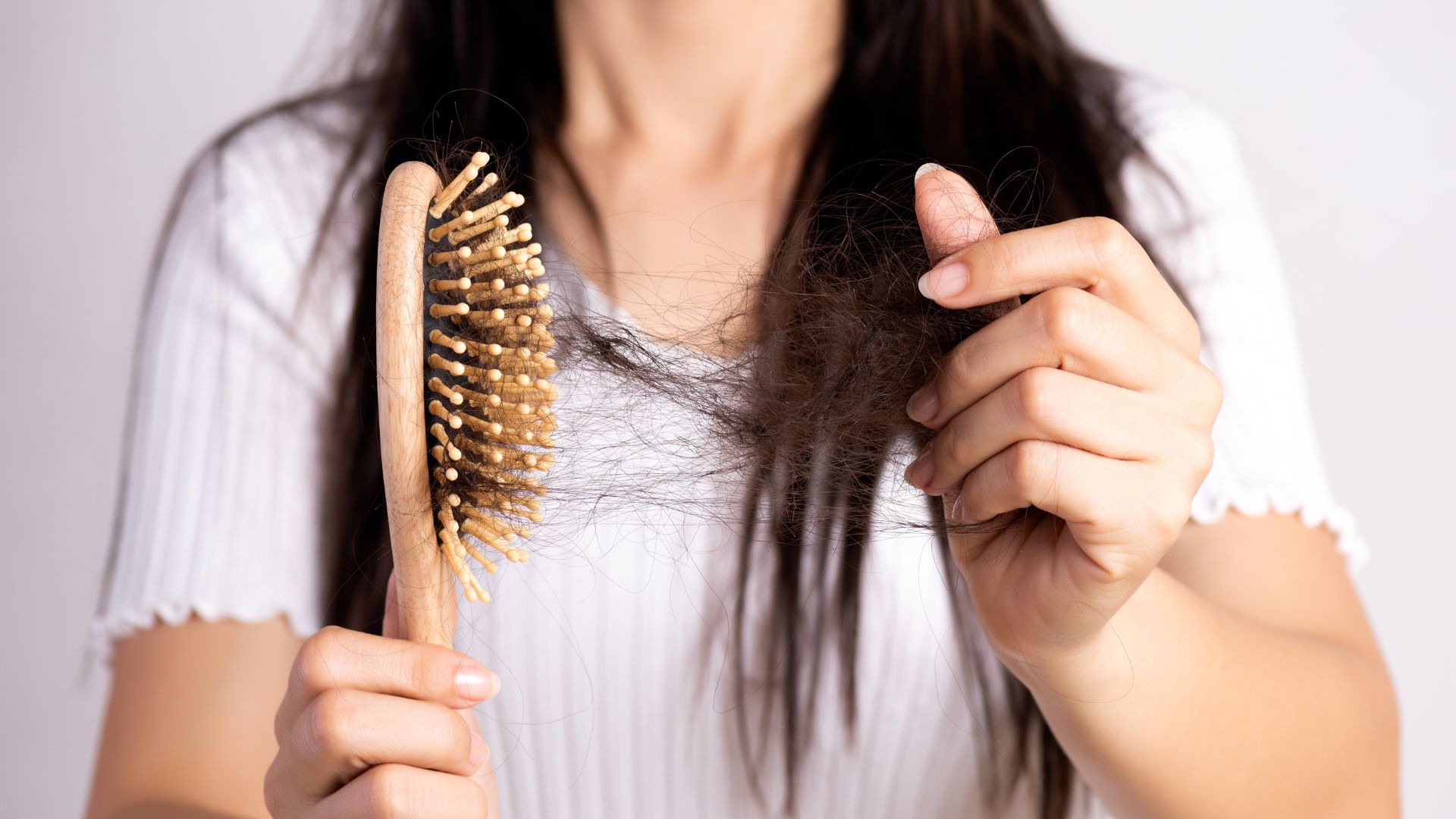 Woman show her brush with damaged long loss hair