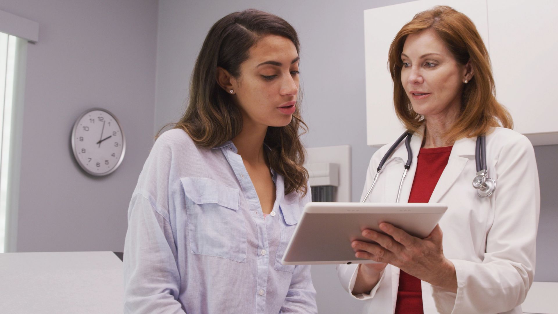 medical doctor using portable tablet to review test results of patient