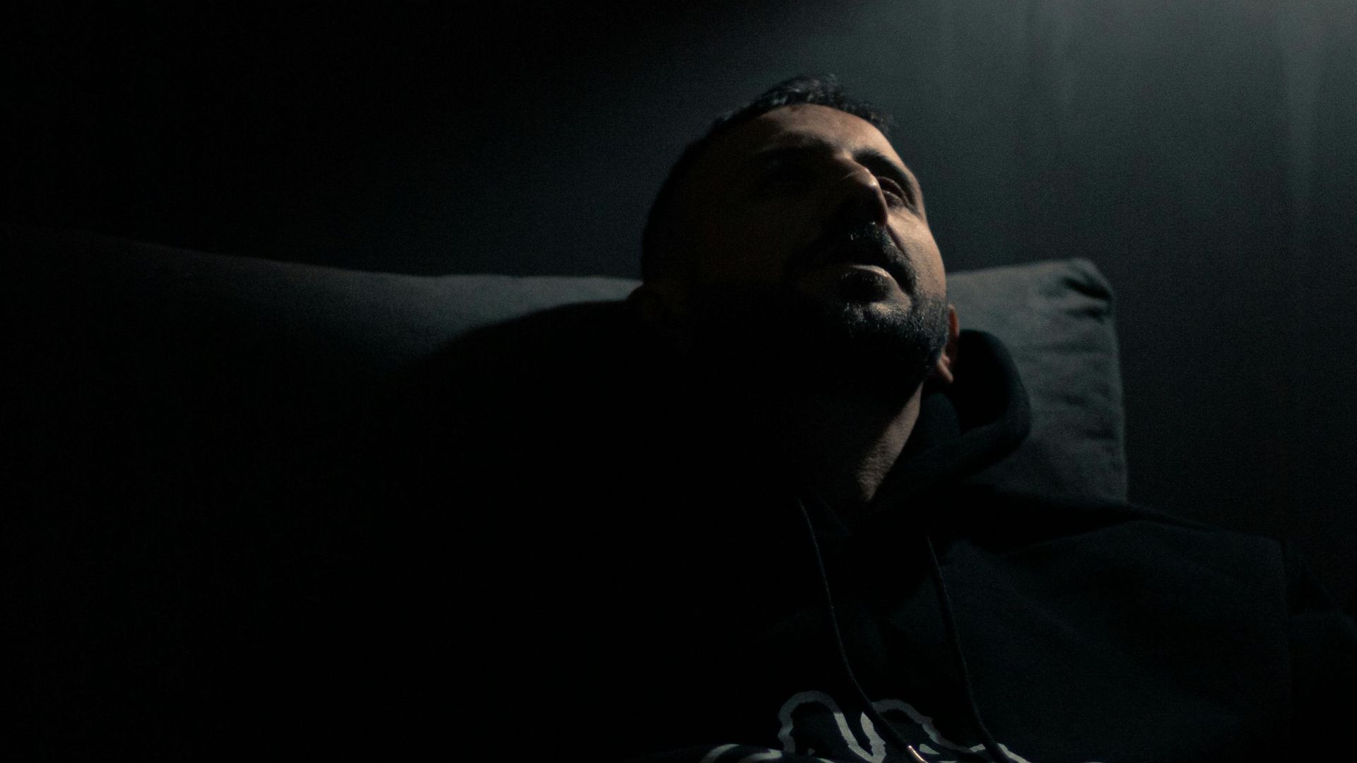 Man Sitting on a Couch Near Lamp