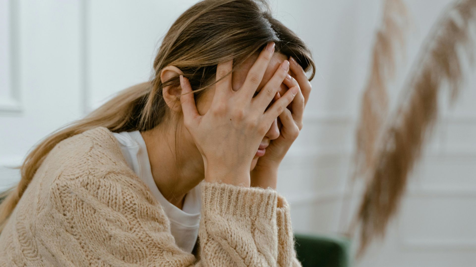 Woman Sitting with Hands Covering Her Face