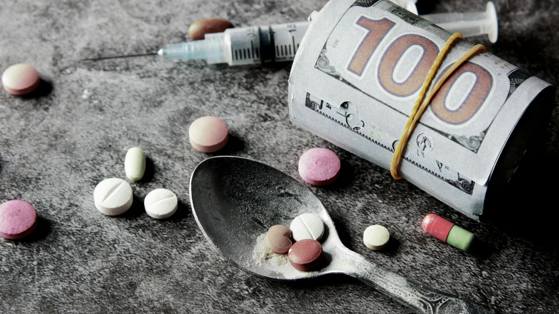 a roll of money and various drugs