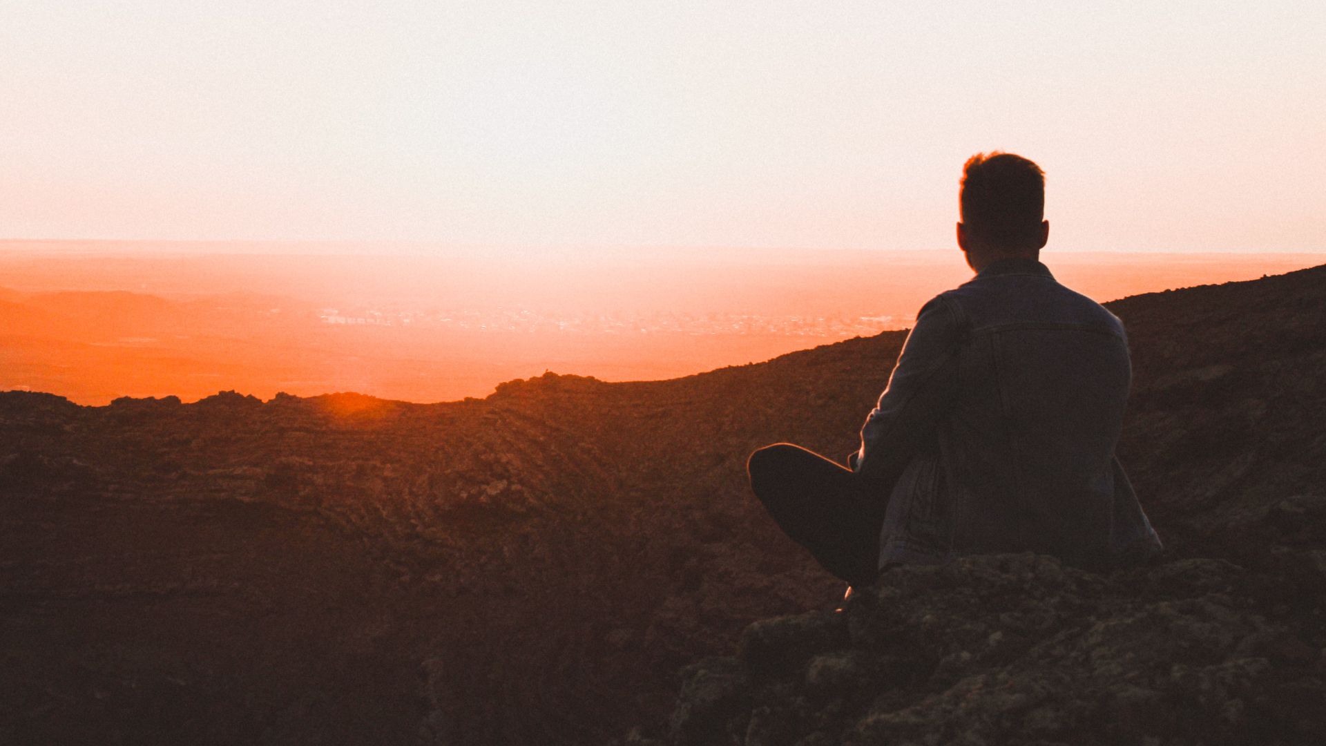 A man sits on a mountain top
