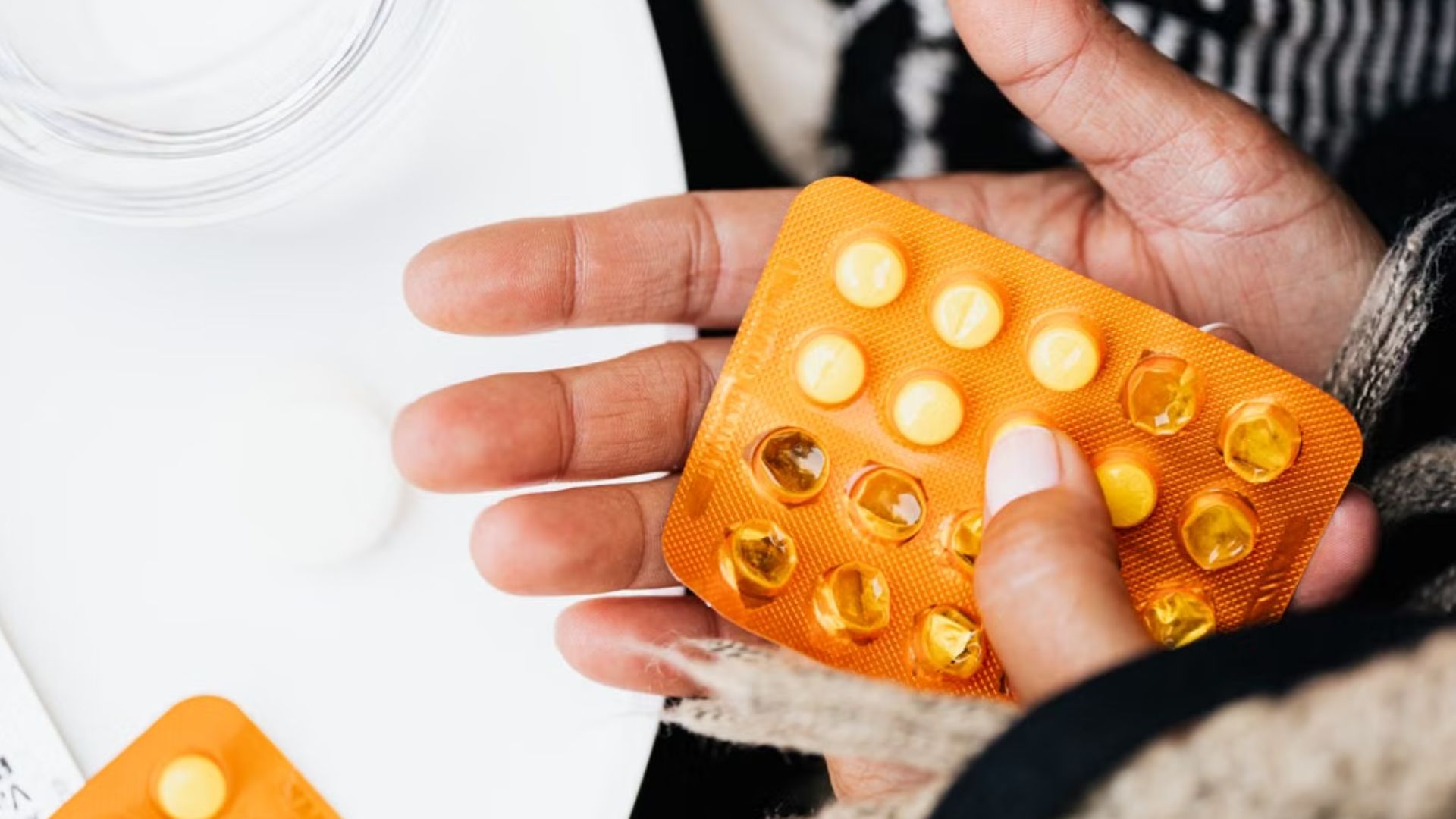 hands holding blister packs of pills